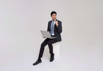 Business. Sucessful asian businessman working with laptop, using computer and smiling, sitting on...