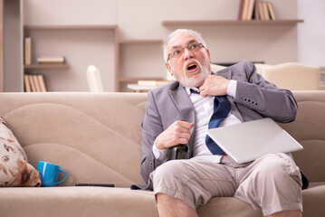 Obraz premium Old male employee working from home during pandemic