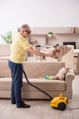 Old man doing housework at home