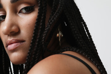 Close-up of young African American woman with braids, posing indoor. Mock-up.