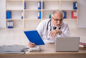 Old male doctor in telemedicine concept