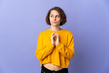 Young English woman isolated on purple background scheming something