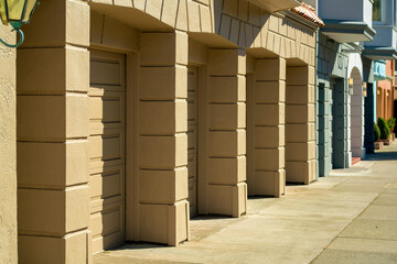 Row of modern downtown garage doors and driveways inside city neighborhood for parking or storing items