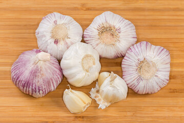Bulbs and cloves of the garlic on a wooden surface