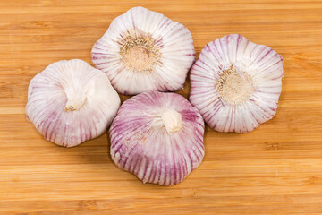 Bulbs of the purple stripe garlic on a wooden surface