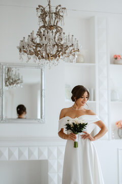 brunette bride in a tight wedding dress in a bright studio