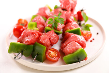 raw beef skewer on plate isolated on white background
