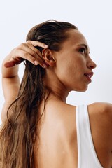 Fototapeta premium A woman with long hair stands back and takes care of her hair after washing and applying scalp and hair health products. Taking care of your hair at home