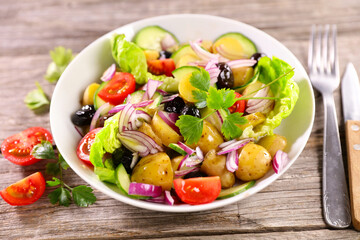 mixed vegetable salad with potato, tomato, olive and onion