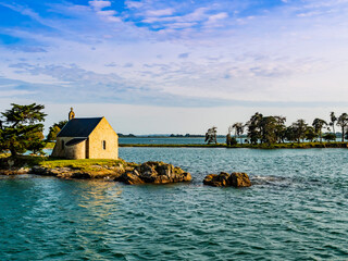 Stunning view of Boedic Island and its famous chapel at sunset, Morbihan Gulf, Brittany, France
