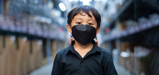 Protective face mask. Asian boy wearing safety face mask in shopping mall warehouse.