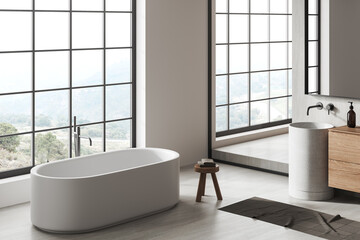 Fototapeta na wymiar Light bathroom interior with sink and bathtub with accessories and window