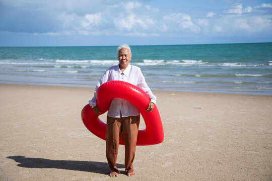 Portrait one mature elderly asian women enjoying summer beach vacations. Bright swimming inflatable ring