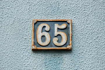 Old retro weathered cast iron plate with number 65