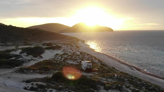 Aerial of camper on grassy Tecolote Beach near La Paz Baja California Sur at sunset