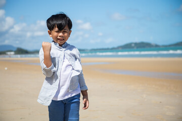 Happy summer holidays travel and vacation on the beach. Portrait Happy Asian kids boy looking at camera on sand beach