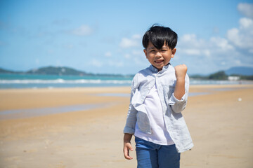 Summer holidays  travel and vacation on the beach. Happy Asian kid smailing and thump up on sand beach.