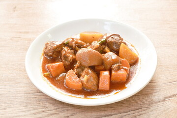 boiled pork leg with carrot in sweet red gravy sauce stew on plate