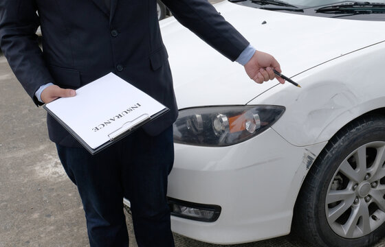 Loss Adjuster Insurance Agent Inspecting Damaged Car.