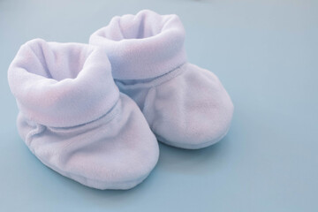 Blue booties for a boy on a blue background. Shoes for newborns