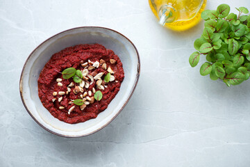 Bowl with caviar made of beetroot, top view on a grey granite background, horizontal shot with space