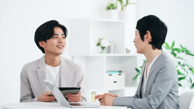 オフィスで会話するビジネスパーソン