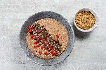 Flaxseed Porridge in a Bowl, Healthy Breakfast or Snack, Porridge Decorated with Chia Seeds and Goji Berries