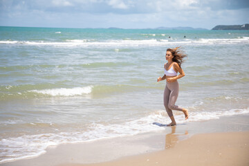 Woman running during outdoor s workout on summer beach