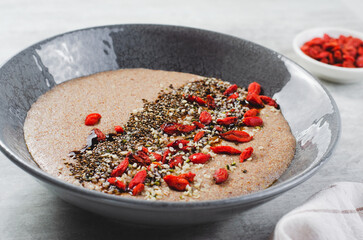 Flaxseed Porridge in a Bowl, Healthy Breakfast or Snack, Porridge Decorated with Chia Seeds and Goji Berries