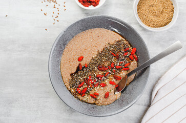 Flaxseed Porridge in a Bowl, Healthy Breakfast or Snack, Porridge Decorated with Chia Seeds and Goji Berries