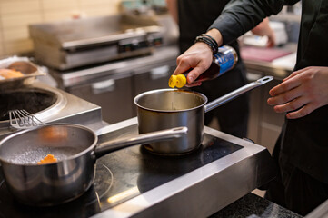 Chef hands cooking sauce in the restaurant kitchen
