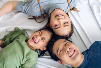 Portrait of enjoy happy love asian family father and mother holding hug cute little asian girl child smiling play and having fun moments good time in at home