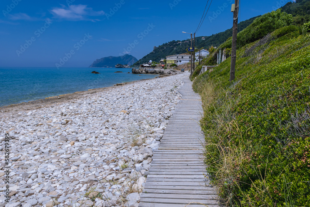 Poster Beach in Agios Gordios village on the Ionian Sea coast, Corfu Island, Greece