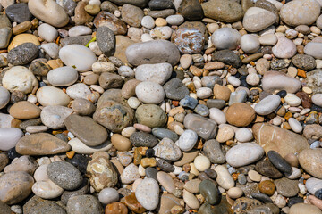 Pebbles on a Ionian coast in Agios Gordios resort village on Corfu Island, Greece