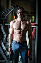 Fototapeta na wymiar Handsome shirtless muscular man with jeans in gym
