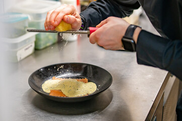 man chef hand cooking one big Ravioli with sauce on restaurant kitchen