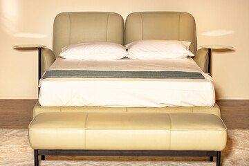 Double bed with a soft leather headboard and mirrored bedside shelves on the sides.