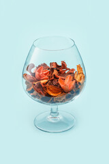A glass with dried flowers on a blue background. Decor, home decoration.