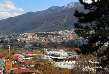 Fototapeta na wymiar A panoramic view of the city of Bursa (Turkey) with many mosques, hans and Uludag mountain in the background against a blue sky with clouds 