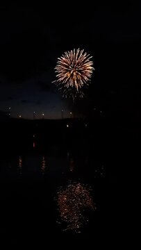 Fast motion of real colourful fireworks above the river. New year's eve, anniversary, independence day, wedding, festival, celebration, show concept. Beautiful abstract background or wallpaper.