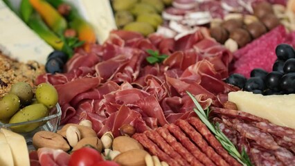 Meat platter with prosciutto, sausage, ham, pork, jamon, cheese. Meat plate rotation slow motion. Antipasto
