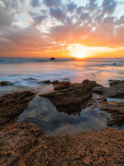 Fototapeta na wymiar Beautiful sunset on the rocky ocean shore.