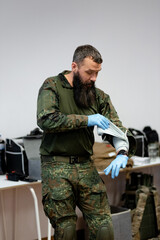 A 40-year-old bearded doctor demonstrates dressing an injured hand with an Israeli bandage