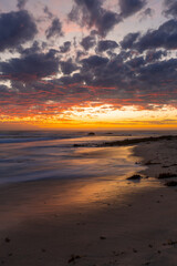 Fototapeta na wymiar Beautiful sunset on the shore with red sky.