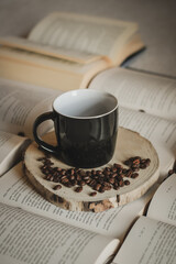 morning coffee, coffee beans and cup on wood and books