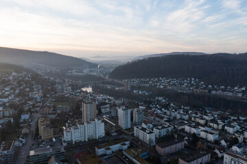 Fototapeta premium Great drone shot above the village called Nussbaumen with the city of Baden in the background in Switzerland.