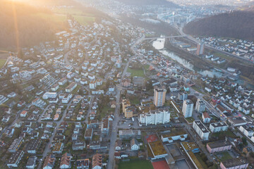Naklejka premium Great drone shot above the village called Nussbaumen with the city of Baden in the background in Switzerland.
