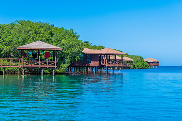 A view out to sea past beach cabanas close to West Bay on Roatan Island on a sunny day