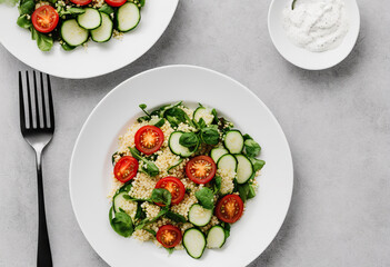 Salad with arabic couscous and vegetables on a white plate