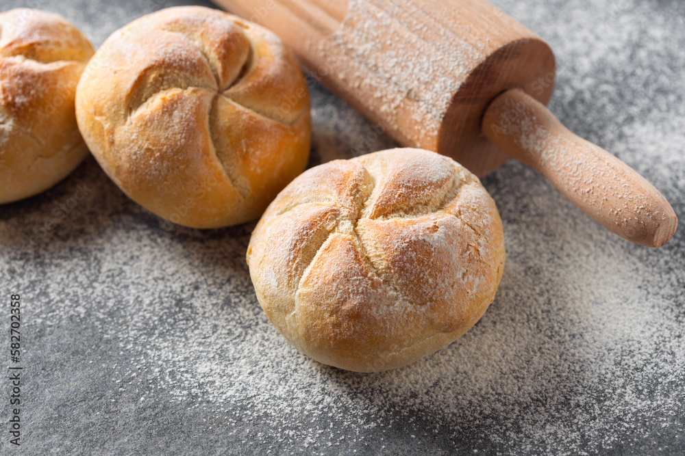 Aufkleber Set of small bun bread on the dark table with rolling pin. Fresh home baking concept